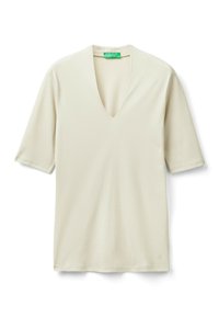 Krémové tričko s krátkým rukávem ve tvaru V s zelenou nálepkou United Colors of Benetton uvnitř límce, položeno na bílé pozadí.