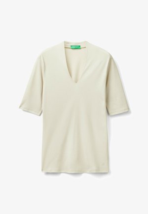 Cream-colored, short-sleeve V-neck shirt with a green United Colors of Benetton label inside the collar, laid flat on a white background.