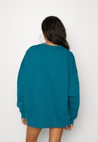 Teal oversized sweatshirt i mjukt material, med ribbade ärmslut och rund halsringning, i en avslappnad passform och sänkta ax seams.