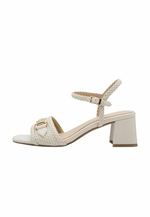 Sandalia blanca de tacón con parte superior trenzada, correa ajustable en el tobillo y detalle en tono dorado. Tacón cuadrado y suela lisa para mayor estabilidad.