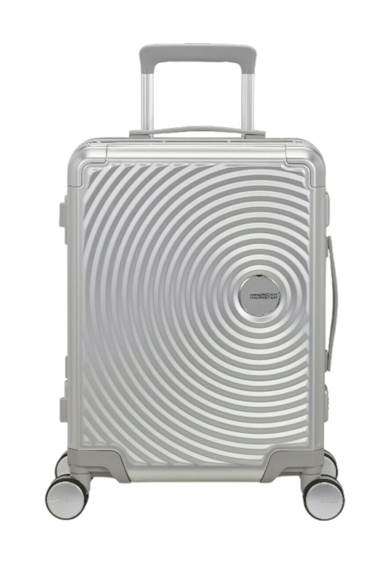 Valigia argentata con superficie a texture a spirale, esterno rigido, manico estensibile e quattro ruote per la mobilità.
