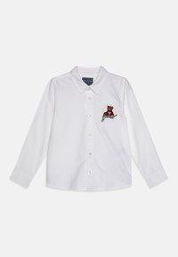Witte lange mouwen shirt met een klassieke kraag, een knoopsluiting aan de voorkant en een geborduurd berenontwerp met de tekst "Guess" op de linkerborst.