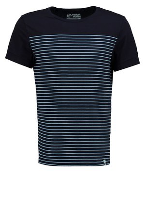 Uomo che indossa una maglietta a righe blu navy e bianche, pantaloncini cargo neri e scarpe da ginnastica nere che cammina su sfondo bianco.