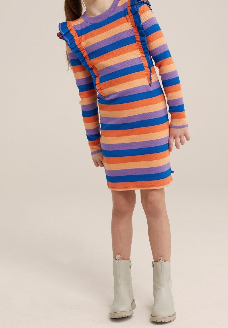 Fille portant une robe à manches longues, longueur genoux, avec des rayures horizontales orange, bleu et violet et des bottines crème sur un fond neutre.