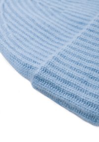 Cappello lavorato a maglia blu chiaro con texture a coste, dotato di risvolto. Materiale morbido simile alla lana, che offre calore e comfort.