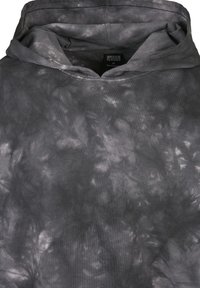 Hooded dukserica s crnim i sivim tie-dye uzorcima, koja se odlikuje mekom teksturom i ležernim krojem. Oznaka vidljiva unutar izreza.