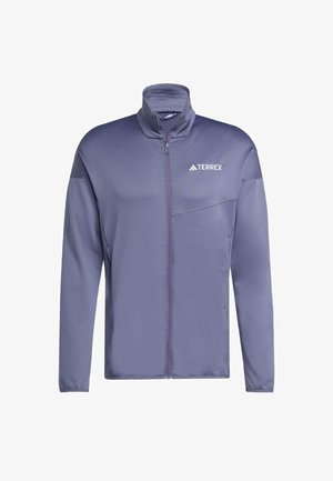 Violet Terrex-takki, jossa on korkea kaulus ja etuvetoketju; siinä on teksturoitu kangas, diagonaaliset olkapääkorostukset ja pieni logo rinnassa.