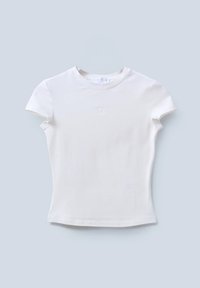Camiseta blanca de manga corta hecha de tela suave, con cuello redondo y logotipo sutil en relieve en la parte delantera. Textura lisa.
