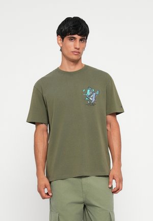Oliven grøn bomulds T-shirt med korte ærmer. Forsiden har et grafisk print af fugle og logo. Rund halsudskæring og afslappet pasform.