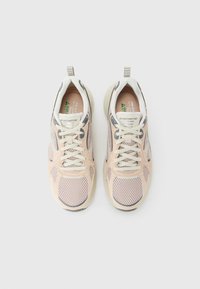 Une paire de baskets Skechers beige et grise avec des détails en mesh et des lacets crème, vue de dessus sur fond blanc.