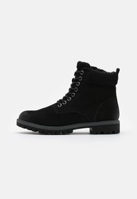 Bottines en suède noir avec un col rembourré, un design à lacets, une semelle en caoutchouc, et des détails texturés sur les côtés pour une meilleure adhérence.