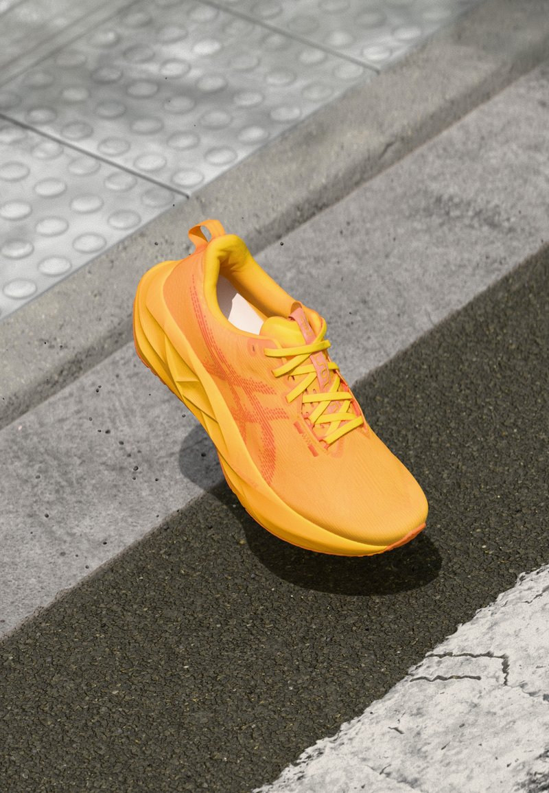 Bright yellow athletic shoe with a sleek design, mesh upper, and textured accents. Features laces and a cushioned sole for comfort.