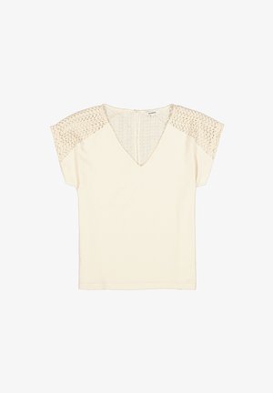 Crèmekleurige top met een V-hals en korte mouwen, met ingewikkeld kanten details op de schouders en een ritssluiting aan de achterkant.