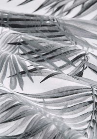 Czarnobiała tkanina z wzorem palmowych liści w różnych odcieniach szarości, o teksturowanym splocie i gładkim wykończeniu.