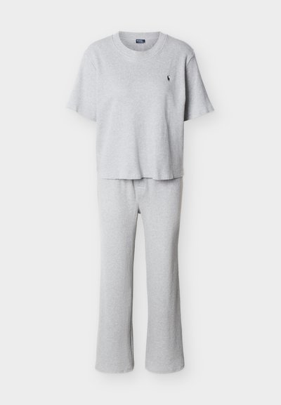 Ανοιχτό γκρι κοντομάνικο ριμπ πλεκτό τοπ με λαιμόκοψη σε στυλ crew και παντελόνι με φαρδύ πόδι, συνοδευόμενο από μικρό μαύρο κεντημένο λογότυπο στο στήθος.