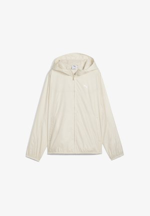 Veste coupe-vent beige clair avec capuche, fermeture éclair à l'avant, poignets élastiques et deux poches latérales. Présente un petit logo blanc sur la poitrine.