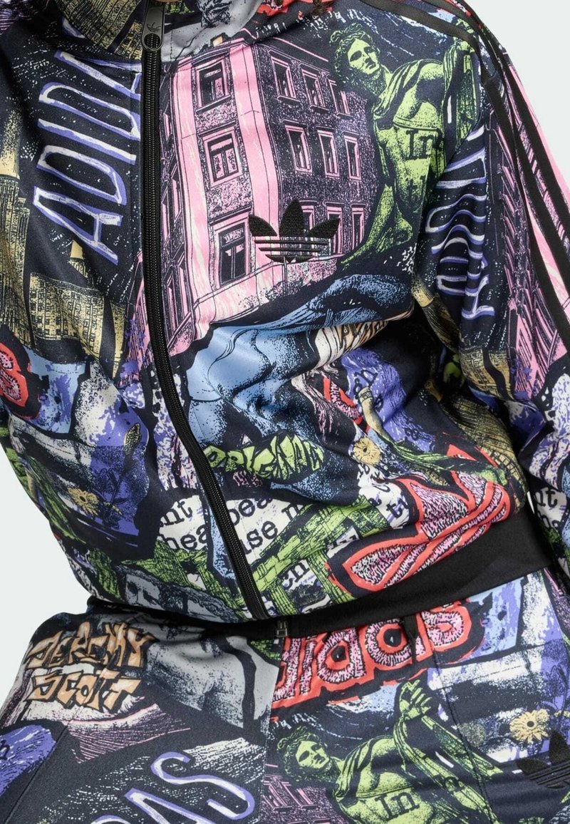 Barevná bunda a kalhoty s graffiti stylizovaným uměním, včetně budov, soch, textu a loga Adidas na hrudi.
