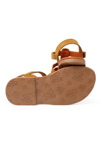 Sandale en daim marron avec plusieurs lanières, un soutien de cheville rembourré et une semelle en caoutchouc à motifs présentant des designs de papillons.