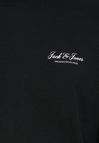 Μαύρο βαμβακερό μπλουζάκι με στρογγυλή λαιμόκοψη, που φέρει λευκό κεντημένο κείμενο που αναγράφει "Jack & Jones" και "ARCHIVE SELECTION" στο στήθος.