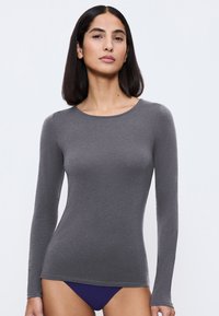 Langsleeve, aansluitend shirt in donkergrijs, gemaakt van zachte, rekbare stof. Heeft een ronde halslijn en naadloze boorden.