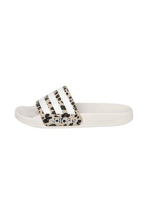 Sandalia tipo chancla blanca de Adidas con tira de estampado de leopardo en negro y beige y tres rayas blancas en la parte superior.