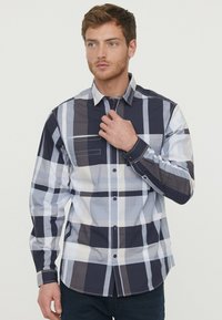 Langarm, knoop-overhemd in een marineblauwe en witte ruitpatroon. Katoenen stof met een gladde textuur en een enkele borstzak.