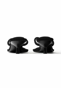 Paire de sandales noires à talons kitten avec fines brides autour de la cheville, vues de dos sur un fond blanc.