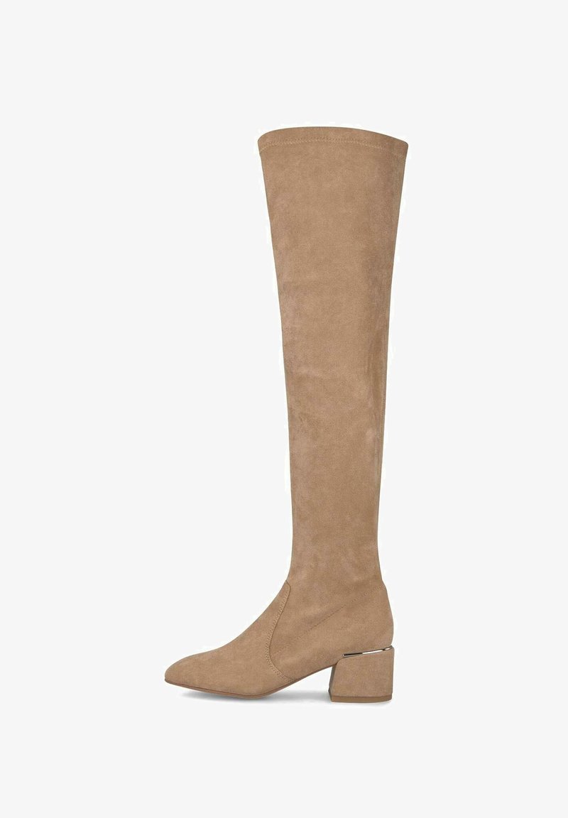 Botas de ante en color beige hasta el muslo, con punta afilada y tacón cuadrado, que presentan un acento metálico en el tacón para mayor detalle. Textura suave.