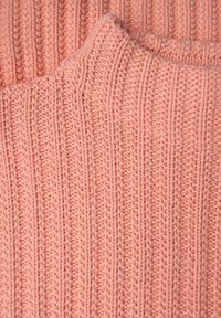 Tissu tricoté rose clair avec des motifs côtelés verticaux, une texture douce et des coutures visibles, superposé pour plus de profondeur.