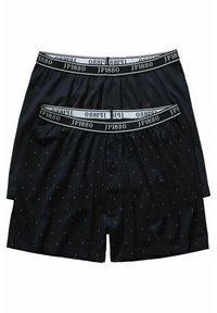 Dos pares de calzoncillos negros con una cinturilla de logo blanca. Un par tiene un patrón de puntos, mientras que el otro es liso.