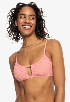 Pink textured bikini top with a keyhole cutout, adjustable straps, and a gathered design along the edges. Made from soft fabric.