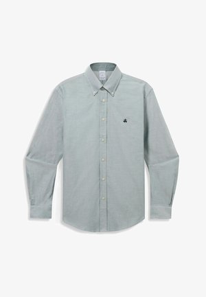 Světlá šedá košile s dlouhým rukávem na knoflíky, s límečkem na knoflíky a malým tmavým vyšitým logem na levé straně hrudníku.