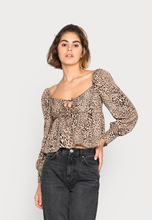 Blusa em estampado de leopardo com mangas bufantes, decote quadrado e detalhe de laço na frente, feita de tecido leve em tons de bege e preto.