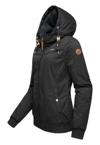 Svart polstret jakke med hette, som har en myk fleecefôr, sidelommer, elastiske mansjetter og brune lærdetaljer på snorene.