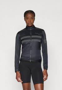 Sort cykeljakke med lange ærmer, frontlynlås og teksturerede vandrette striber; parret med sorte shorts. Letvægts, strømlinet design.