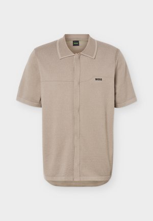 Μπεζ κοντομάνικο πόλο με γιακά, κρυφό κούμπωμα και λογότυπο "BOSS" στο αριστερό στήθος.