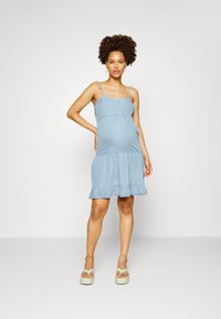 Vestido de alças azul claro, feito de tecido suave, apresentando um corpete ajustado, uma bainha com camadas de babados e alças de espaguete ajustáveis.