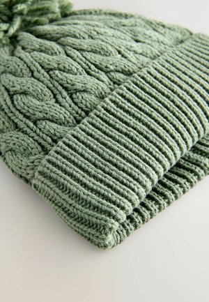 Grüne Kabelstrick-Mütze mit geripptem Bund und Pompon oben, aus weichem Material gefertigt, mit aufwendigen Texturmuster.
