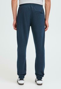 Marineblauwe sweatpants met elastische tailleband, slim fit en een klein achterzakje. Gemaakt van een zachte, gestructureerde stof met geborduurde enkels.