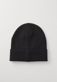 Bonnet en tricot noir avec une texture douce, un sommet arrondi et un revers replié, ne présentant aucun motif visible ni pièce métallique.
