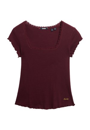 T-shirt bordeaux côtelé avec de courtes manches avec volants, décolleté carré et ourlet en croissant. Présente un petit logo doré brodé sur le devant.