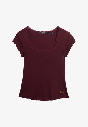 T-shirt bordeaux côtelé avec de courtes manches avec volants, décolleté carré et ourlet en croissant. Présente un petit logo doré brodé sur le devant.