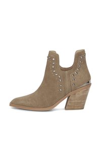 Beżowe zamszowe botki za kostkę z ostrym noskiem, z ozdobnymi ćwiekami i teksturowanym brązowym obcasem na słupku. Posiadają niski krój i są łatwe do założenia.