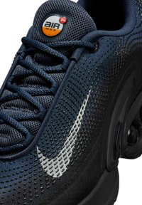 Sneaker Nike Air Max con una tomaia in rete blu scuro a trama, suola in gomma nera, grande swoosh bianco e un logo "Air" rotondo.