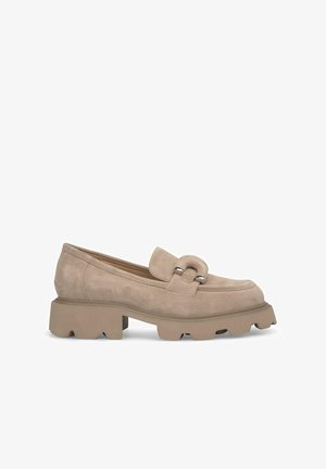 Mocasines de ante beige con suela de plataforma gruesa, que cuentan con un acento decorativo de metal en la parte frontal. Textura suave y forma redondeada.