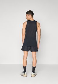Top lejer fără mâneci de culoare neagră și șorturi negre, fabricate din material ușor. Design solid, fără modele sau accente vizibile.