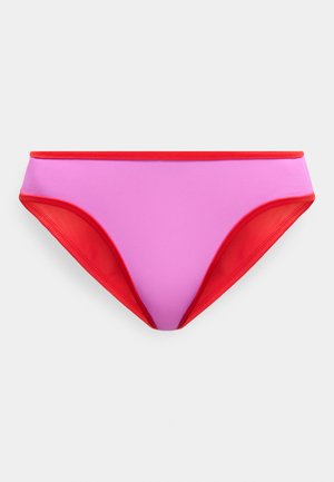 Μαγιό σε στυλ bikini χαμηλής μέσης σε ροζ χρώμα με κόκκινα περιθώρια κατά μήκος της μέσης και στα ανοίγματα των ποδιών, τοποθετημένο επίπεδα σε ανοιχτό φόντο.