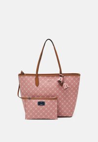 Vaaleanpunainen kassi, jossa on ruskeat nahkaosat ja lehtikuosiset yksityiskohdat. Mukana on pienempi, yhteensopiva pussukka, joka on suljettu vetoketjulla.