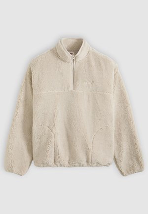 Beige fleecegenser med glidelåskrage, teksturert overflate, frontlommer og en horisontal søm over brystet.