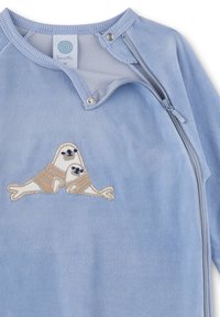 Blaues Fleece-Kleidungsstück mit teilweisem Reißverschluss und Druckknopf, mit einem gestickten Design von zwei Robben, die gestreifte Pullover tragen. Weiche Textur.